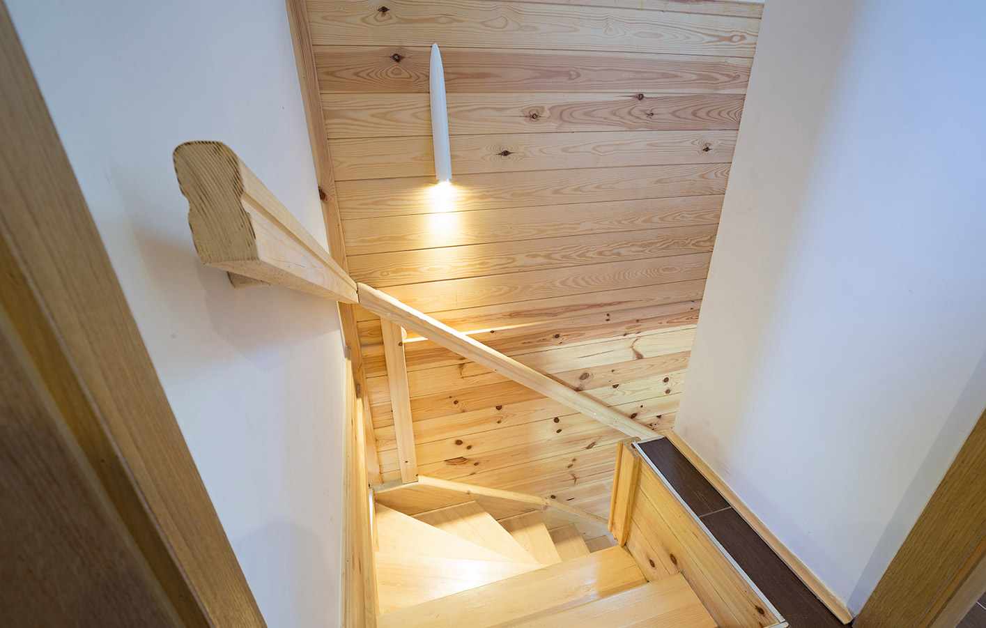 Treppenaufgang mit einer Wand aus Massivholzpaneelen